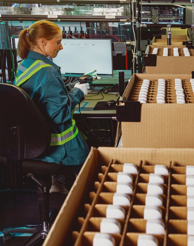 Woman scanning IQOS Holder in factory